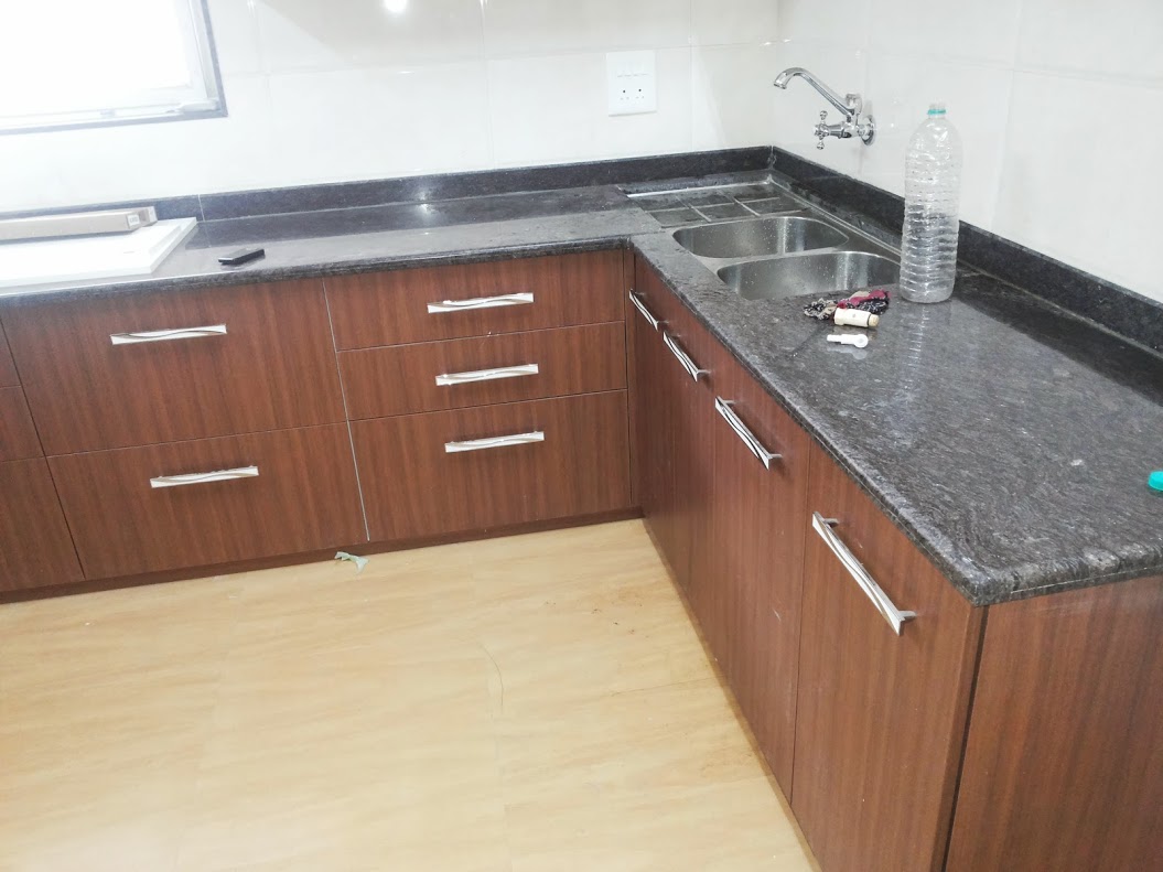 Contemporary L-shaped modular kitchen with modern cabinetry and appliances.