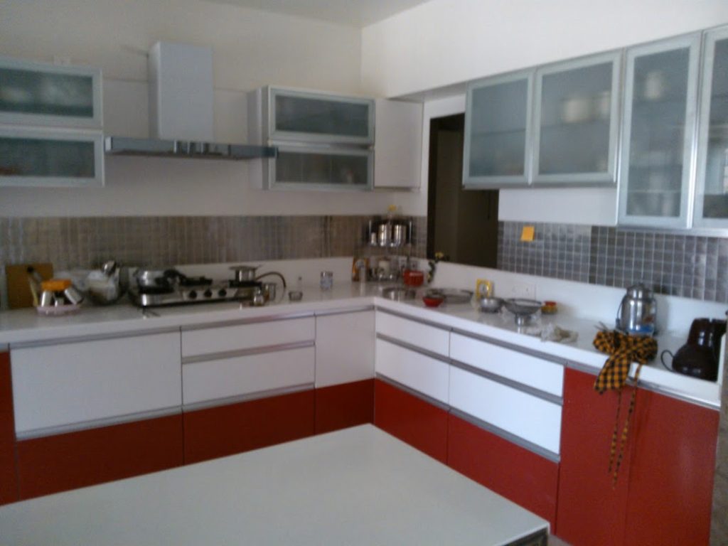 Elegant white and chocolate color modular kitchen featuring sleek cabinetry, modern appliances, and stylish countertops