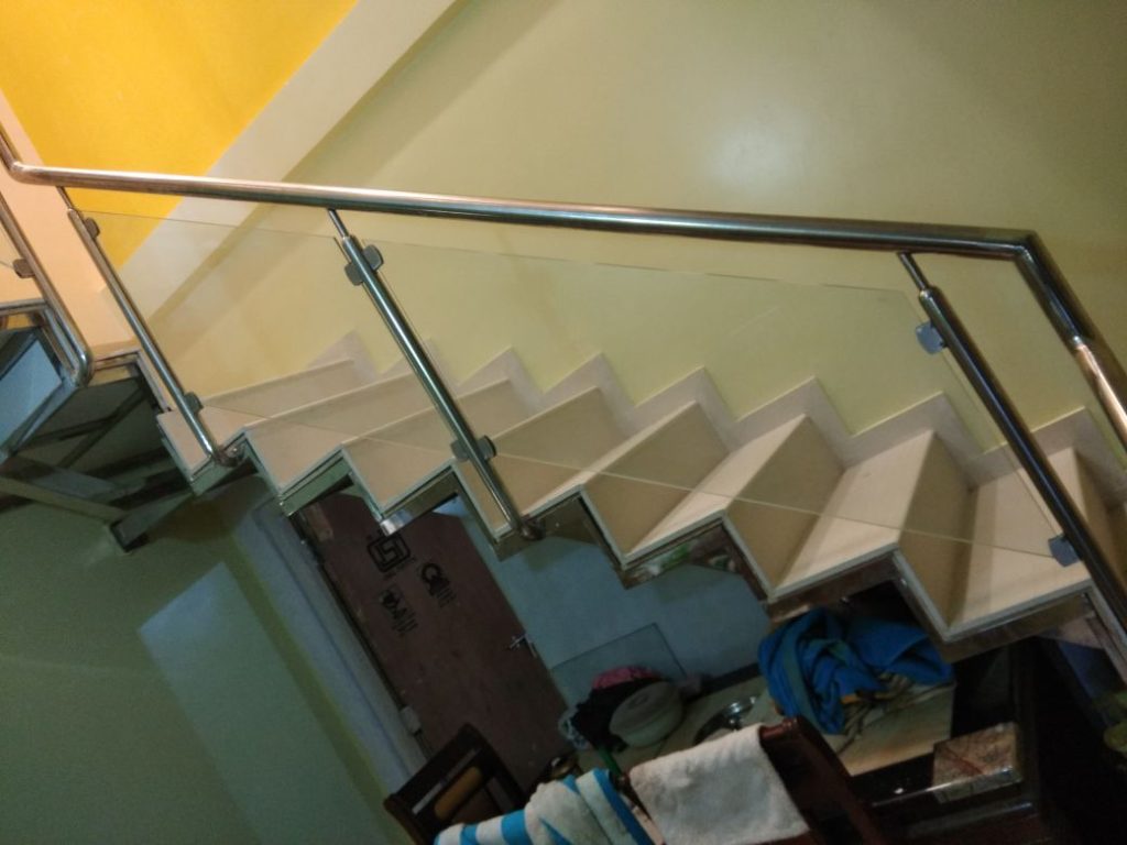 Glass staircase railing with stainless steel handrail