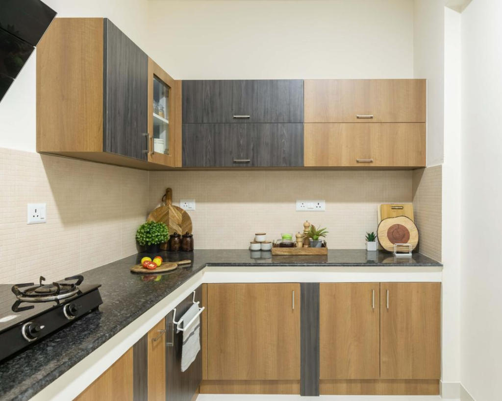 L-shaped kitchen with brown and dark gray cabinets, black granite countertop, and a gas stove on the left.