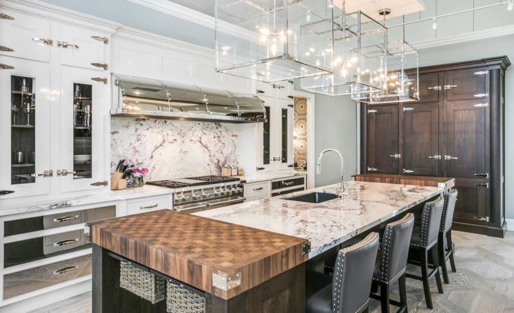 Alt Text: Premium modern modular kitchen with white cabinets, marble backsplash, and wooden island